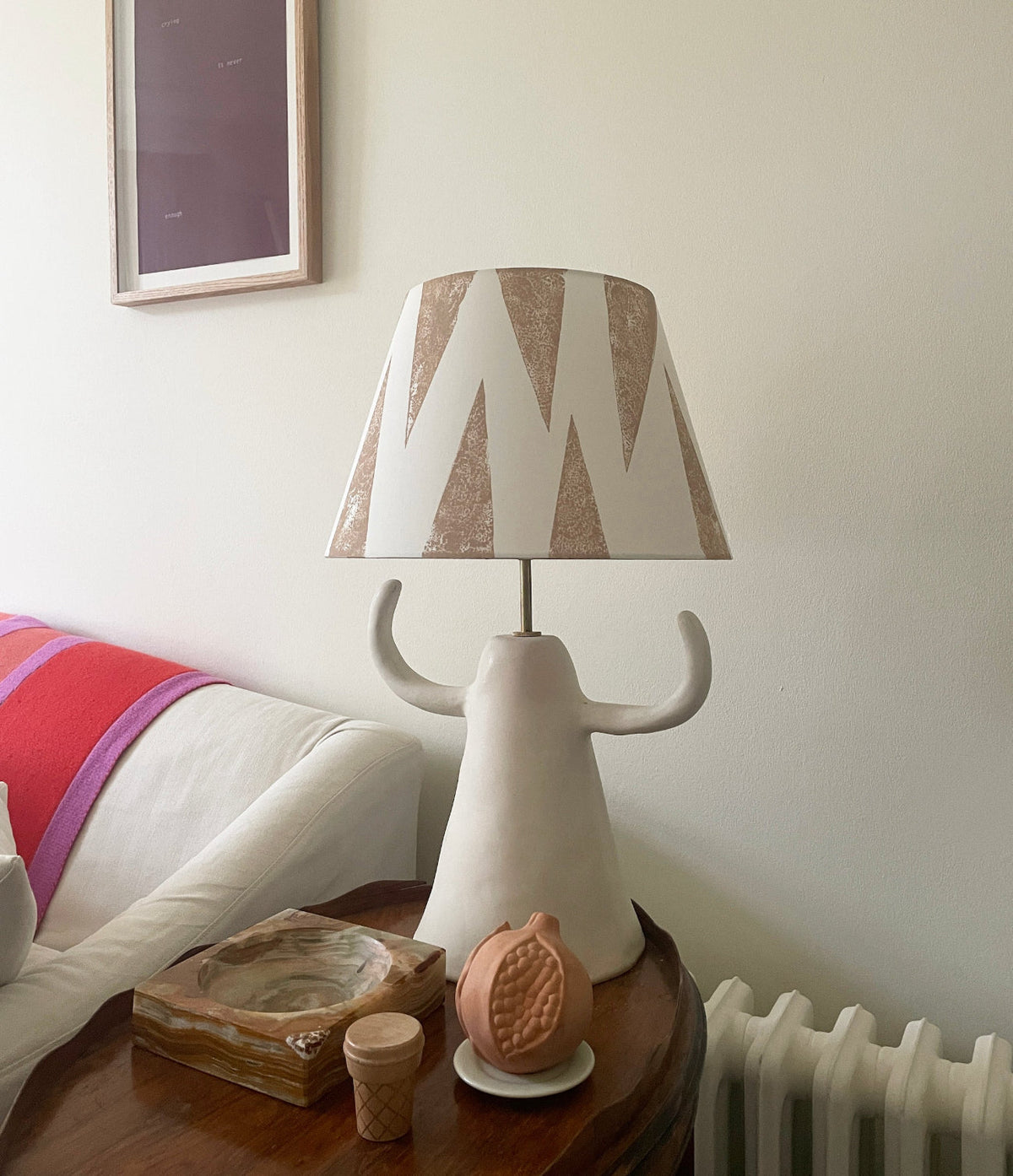 Cream empire lampshade with soft pink geometric triangle pattern styled on a sculptural ceramic lamp base. A bold lampshade with a neutral tone, ideal as a geometric lampshade for contemporary living rooms.