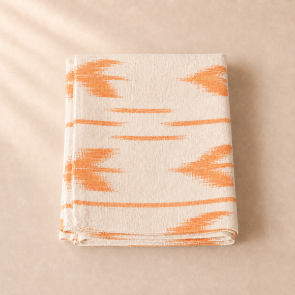 Table runner with orange abstract pattern on a beige background