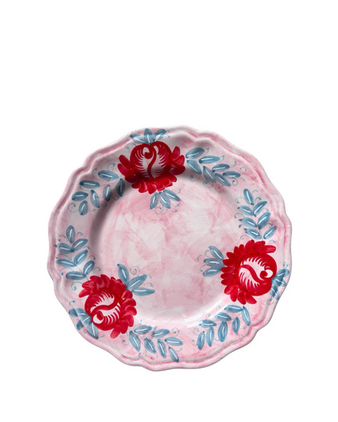 Decorative plate with red floral designs on a pink background