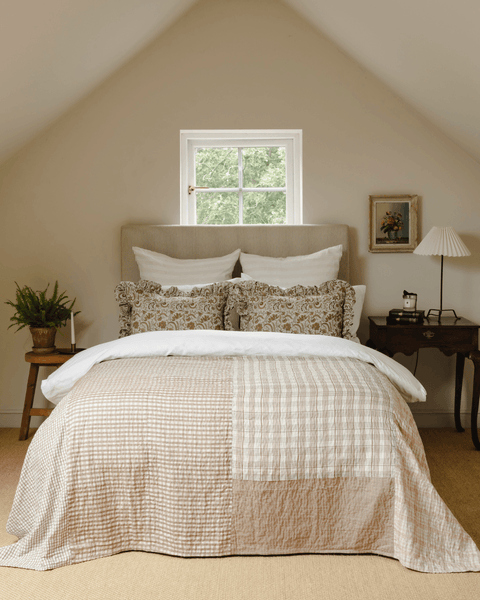 A bedroom image styled with The Old And New Companys patchwork house throw and the Betsy frill cushions