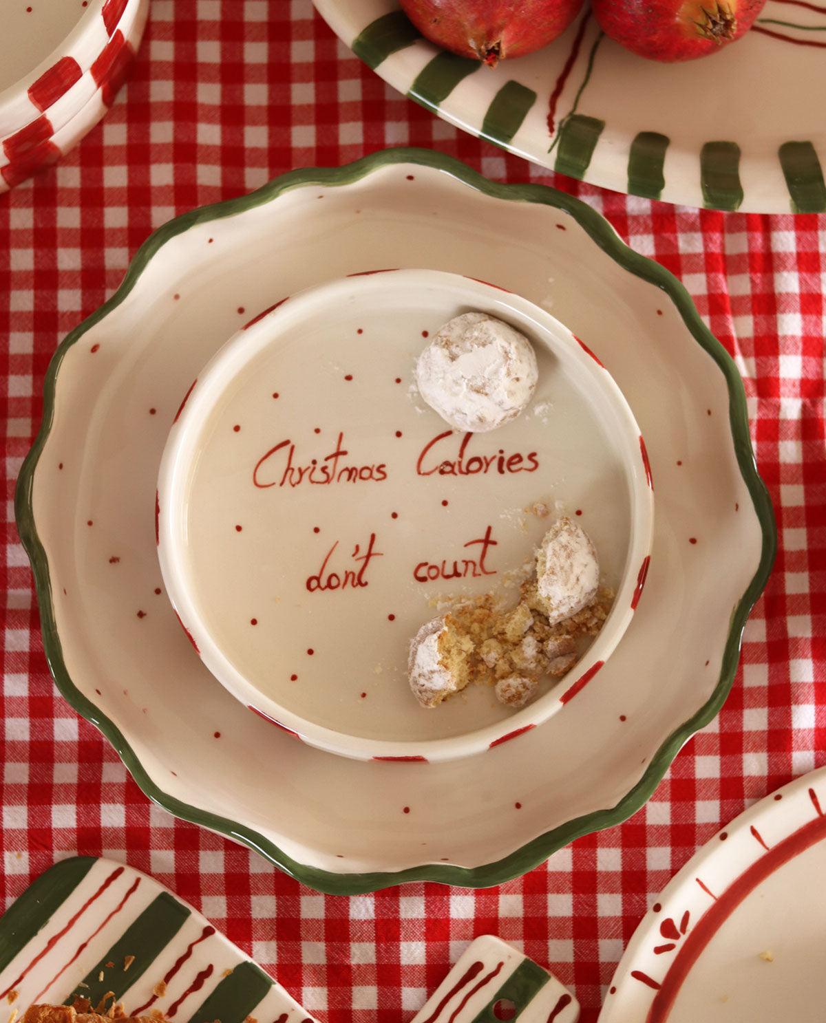 Decorative plate with 'Christmas Calories don't count' text on a red checkered tablecloth.