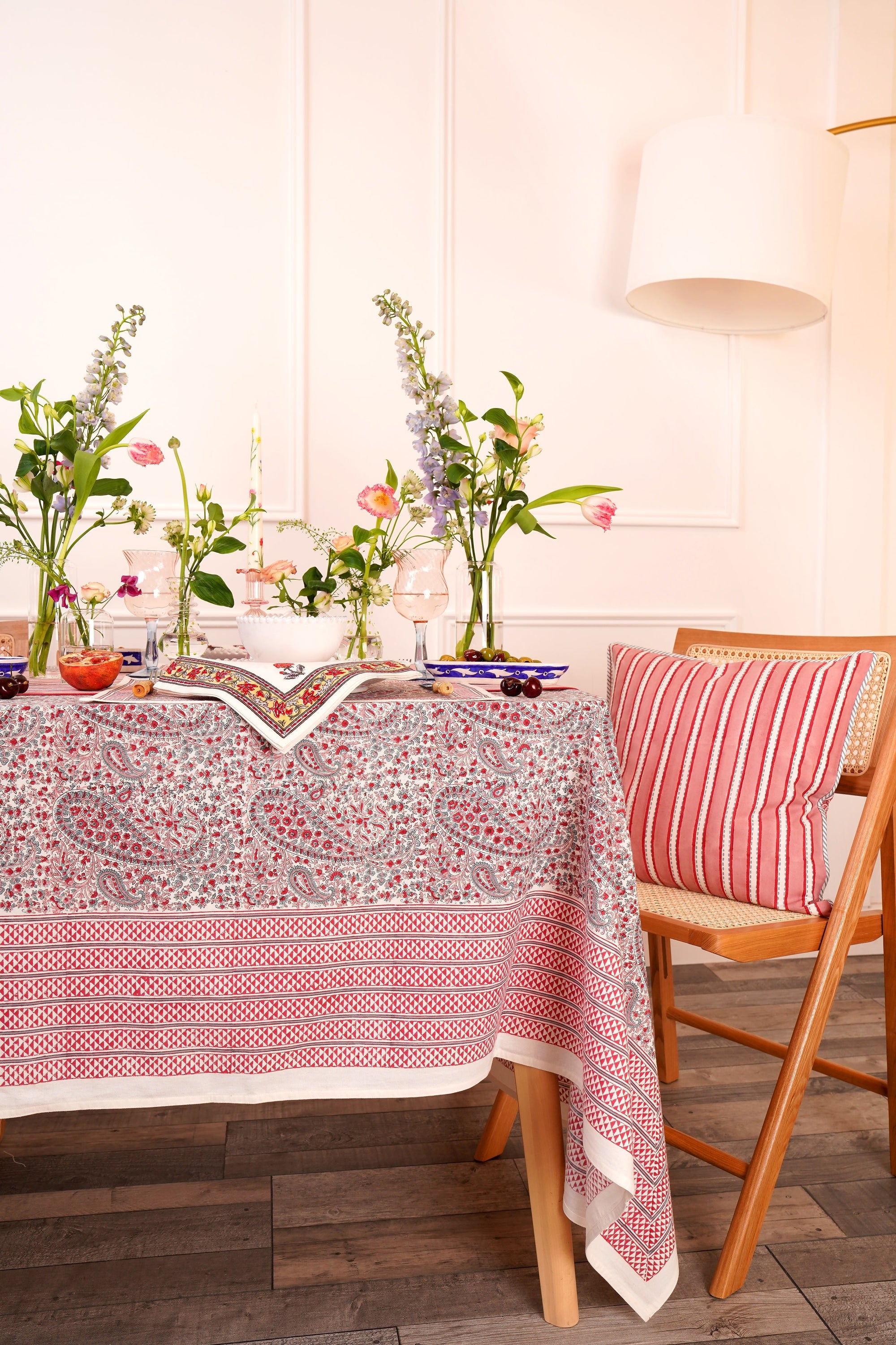 Pink block printed tablecloth with paisley pattern on a dining table styled with blcok printed napkins and table mats