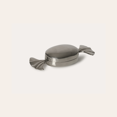 Metallic candy-shaped container on a light gray background