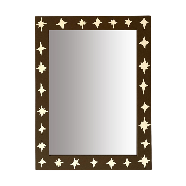 Rectangular mirror with star-shaped cutouts on a brown frame against a white background