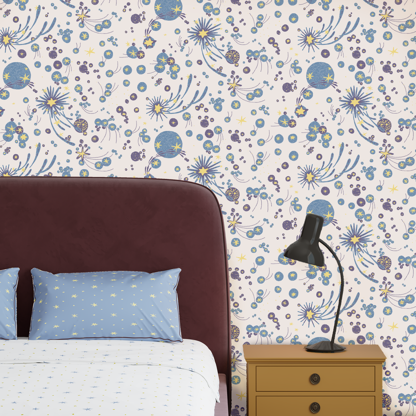 Bedroom with bold stars wallpaper, upholstered headboard, and nightstand. Wallpaper Solaris in white.