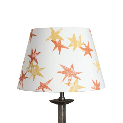 A stand-alone product shot of the Wonky Stars Lampshade in cream with scattered orange and yellow star prints. A bold lampshade and empire lampshade, perfect as empire shades for table lamps or kids lampshade styling.