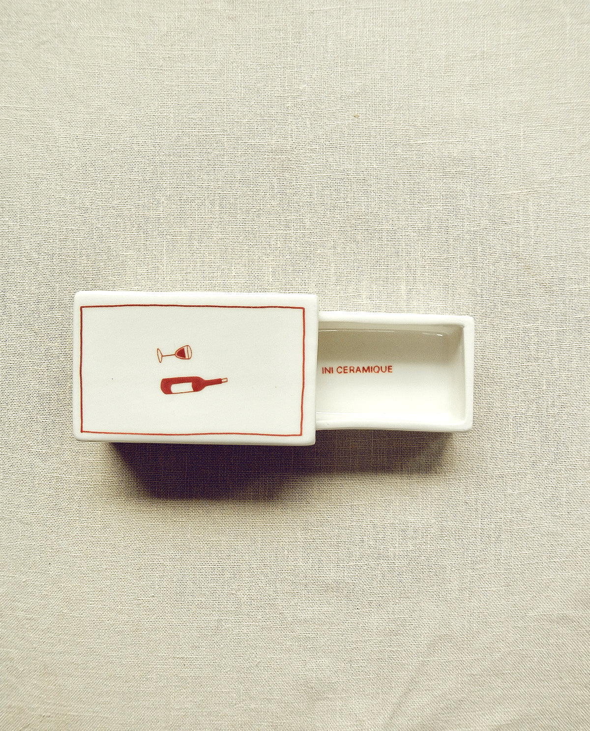 Hand-illustrated ceramic matchbox with wine bottle and glass illustration