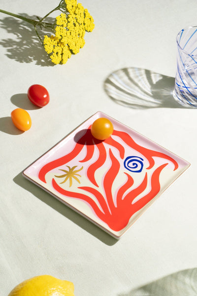 The Octaevo Amalfi Ceramic Tray features Mediterranean coral motifs and holds a yellow tomato—an ideal, stylish gift.