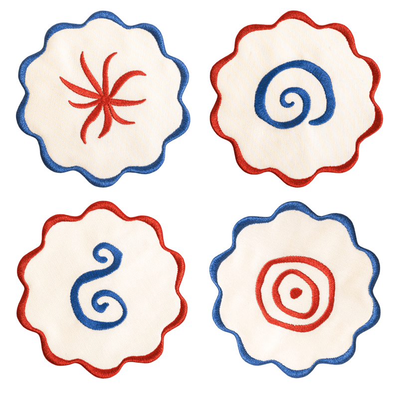 The Amalfi Coasters set by Octaevo features 4 white linen-cotton coasters with blue or red scalloped swirl embroidery.