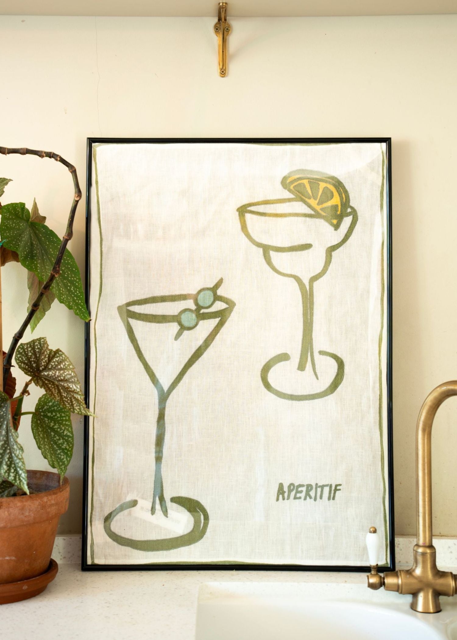 Apertif illustrated linen tea towel framed in a kitchen