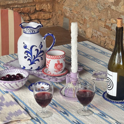 Table setting with wine, glasses, and a bottle in a rustic outdoor setting. - lifestyle