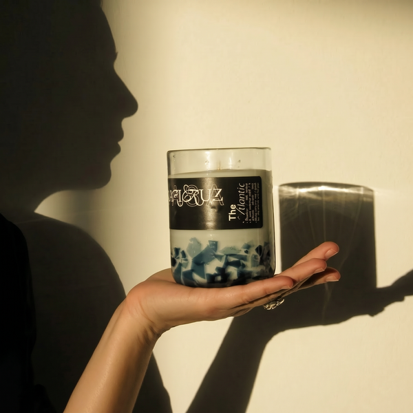 Person holding a candle labeled 'The Atlantic' against a plain background - lifestyle