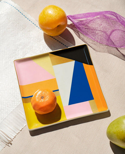 The Bazaar Ceramic Tray by OCTAEVO features a geometric design and gold details, ideal as a stylish gift. 