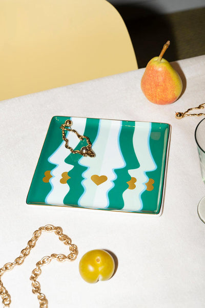 The green Octaevo Beso Ceramic Tray adds chic style to your table, paired with gold accents, fruit, and glassware.