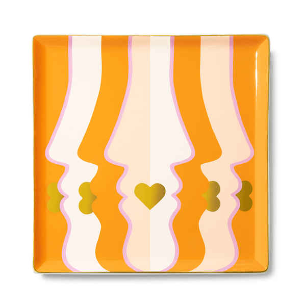 The Beso Ceramic Tray by Octaevo features abstract orange faces, gold hearts, and is perfect for a chic gift or tablescape.