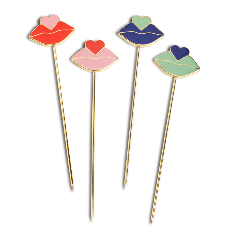 OCTAEVO’s Beso Cocktail Picks (Set of 4) feature gold-plated picks with lips and hearts in red, pink, blue, and green.