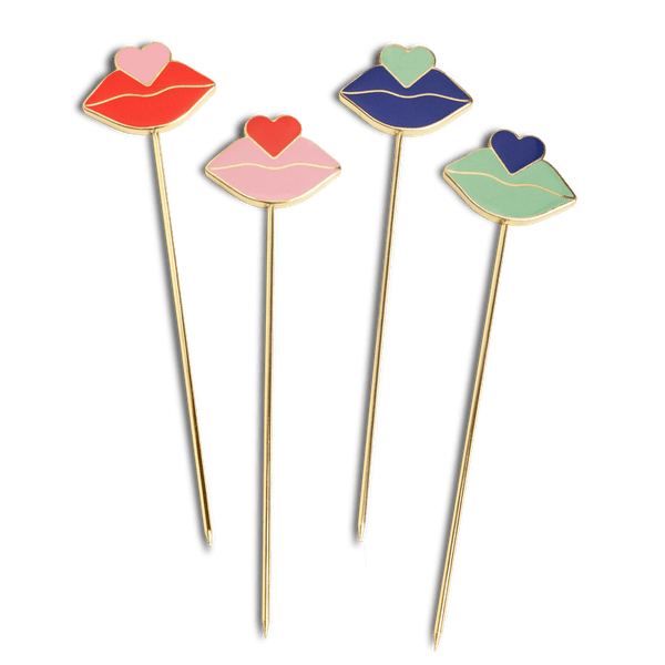 OCTAEVO’s Beso Cocktail Picks (Set of 4) feature gold-plated picks with lips and hearts in red, pink, blue, and green.