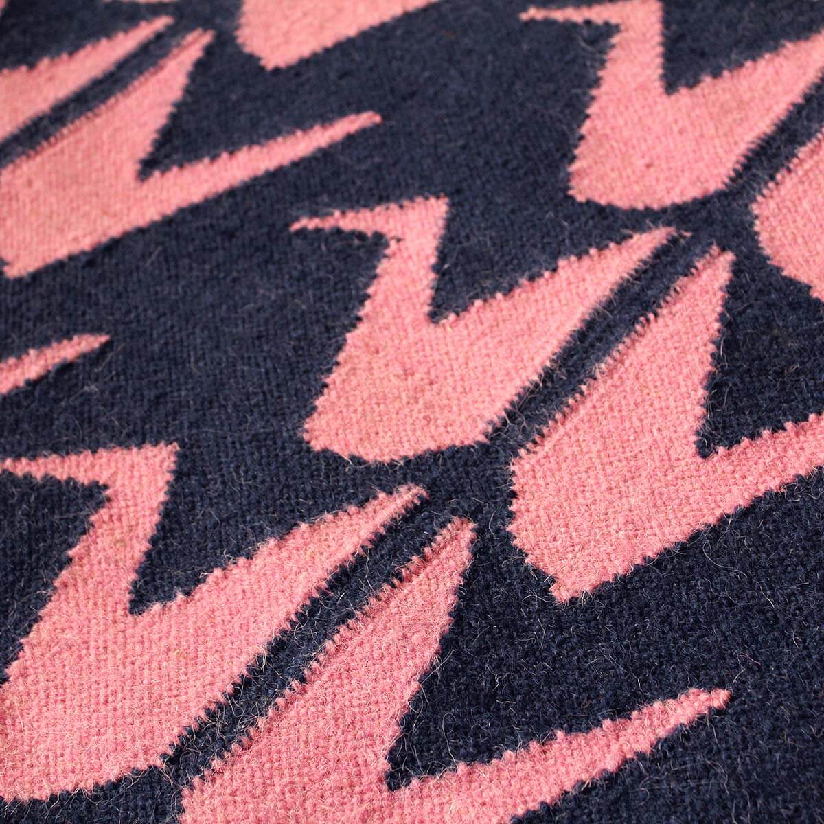 Detail of handwoven dark blue and pink flatweave wool rug