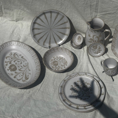 Set of ceramic plates and cups on a textured fabric surface - lifestyle