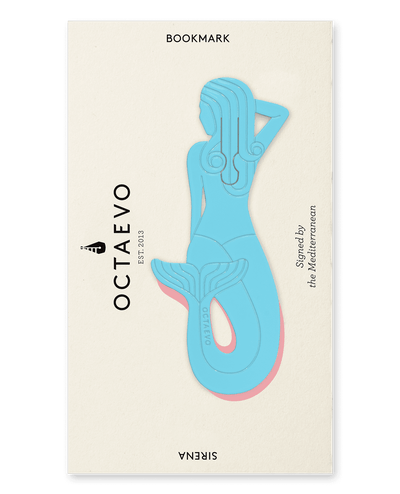 The Bookmark Sirena by OCTAEVO is a light blue brass mermaid resting on a cream card, Signed by the Mediterranean.