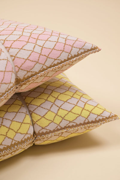 detail of pink bow-shaped knit pillowcase with romb pattern in viscose