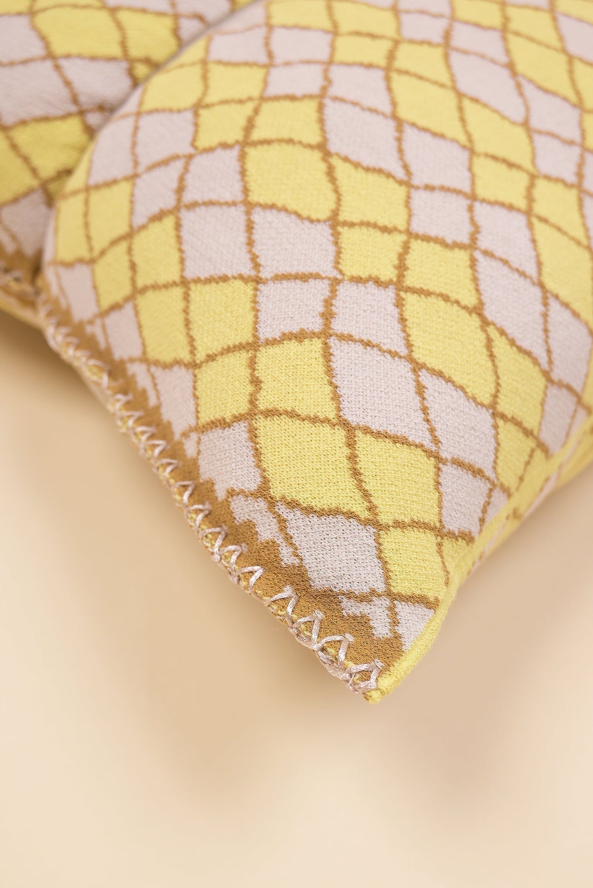 corner detail of bow-shaped knit pillowcase with romb pattern in viscose