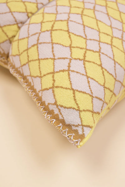 corner detail of bow-shaped knit pillowcase with romb pattern in viscose