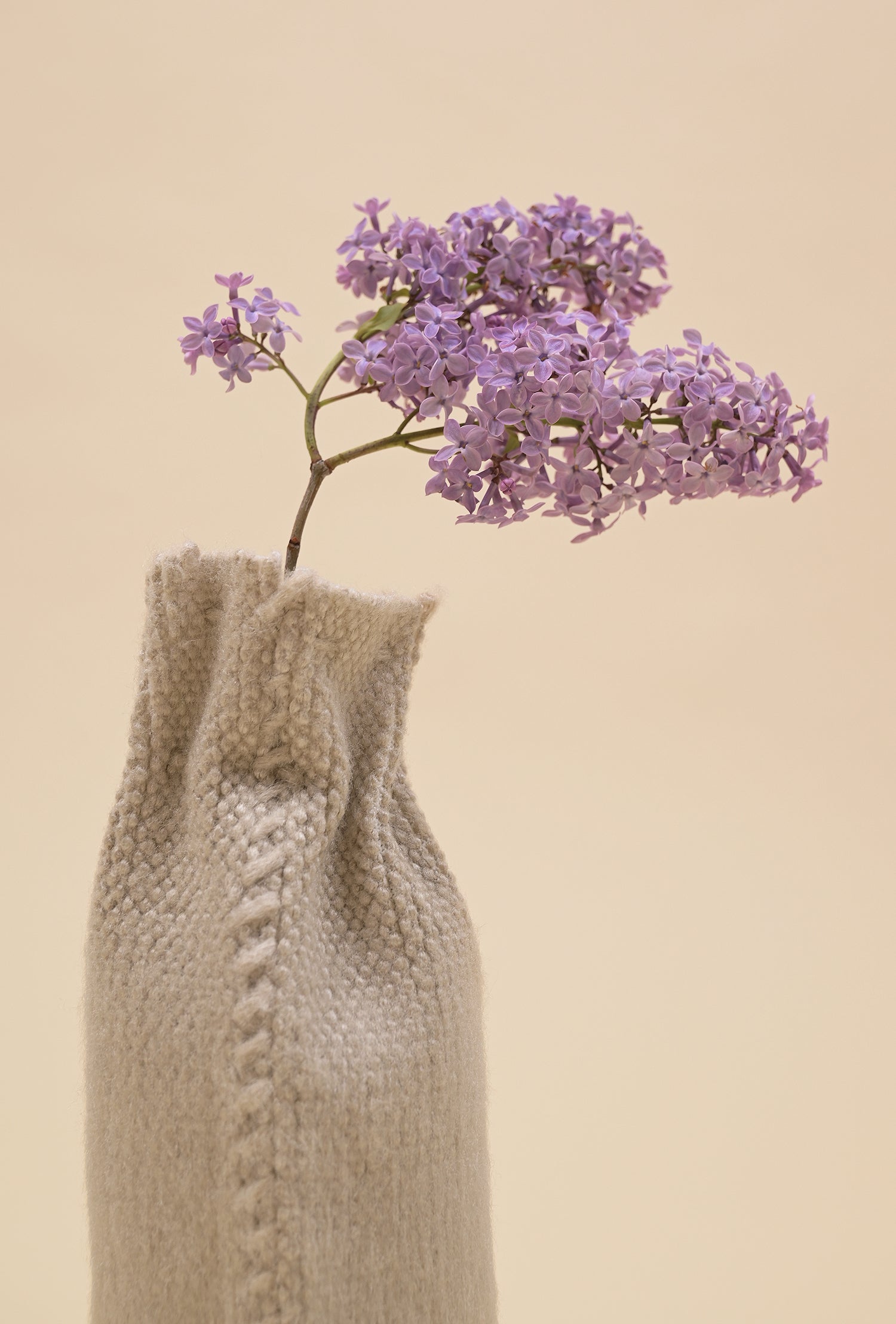 close-up of back side of beige knit textile vase in brushed silk and organic cotton
