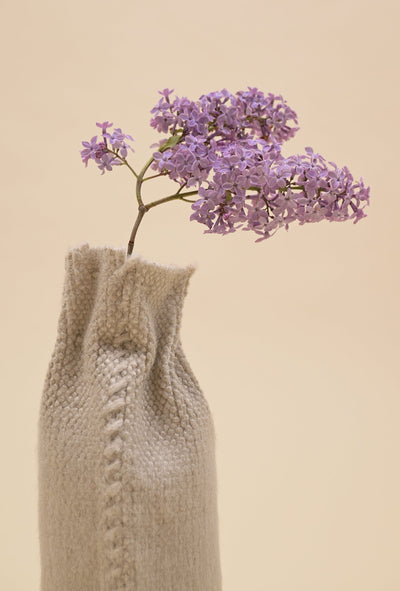 close-up of back side of beige knit textile vase in brushed silk and organic cotton
