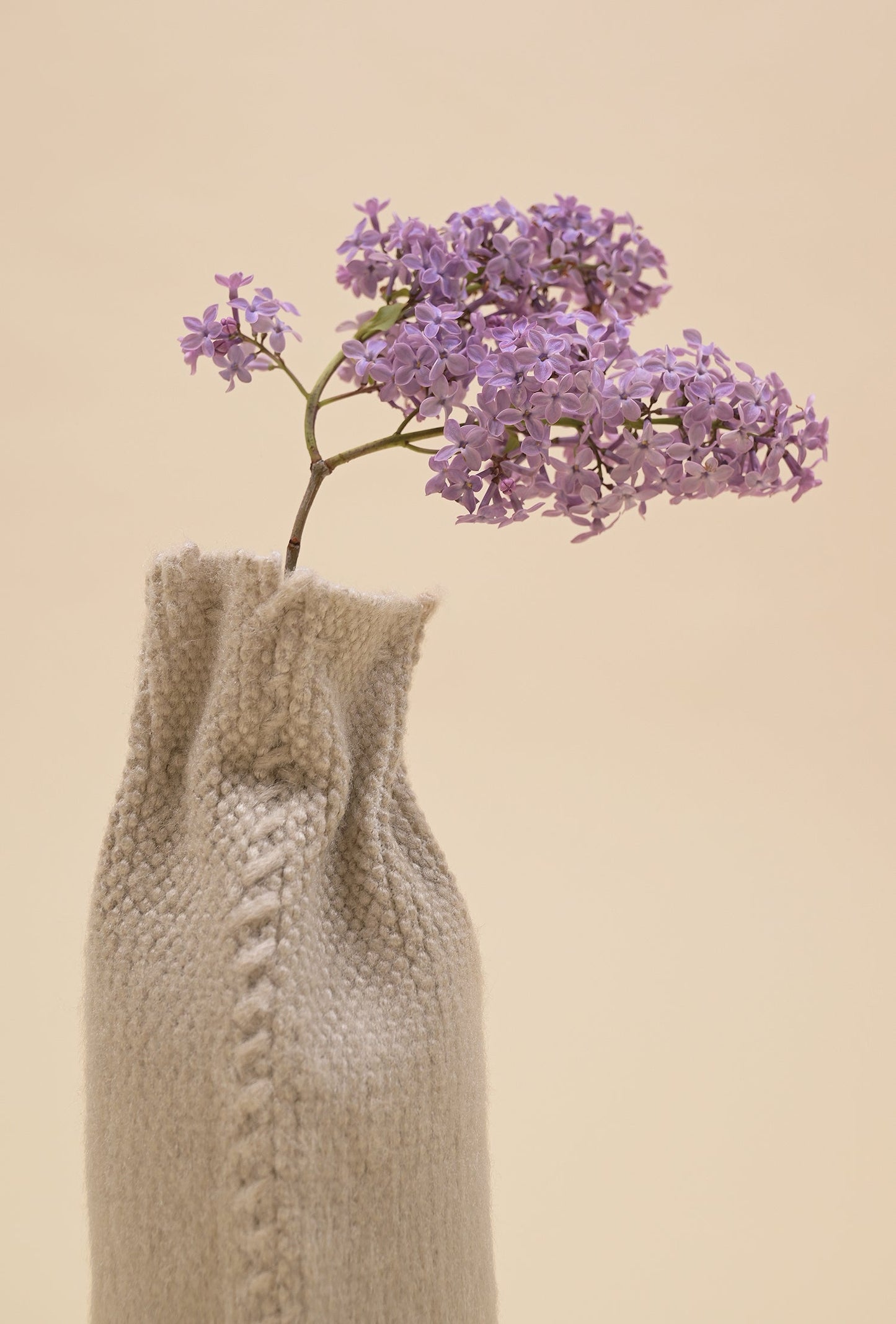 close-up of back side of beige knit textile vase in brushed silk and organic cotton
