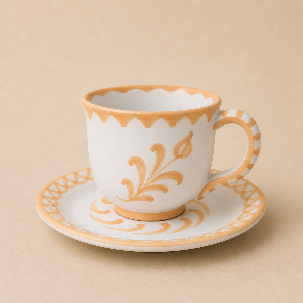 Ceramic cup and saucer with orange floral patterns on a beige background