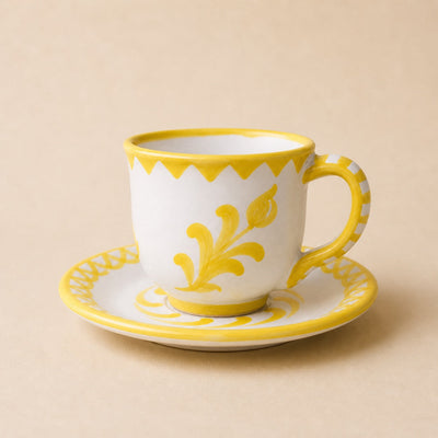 White mug with yellow floral design on a beige background