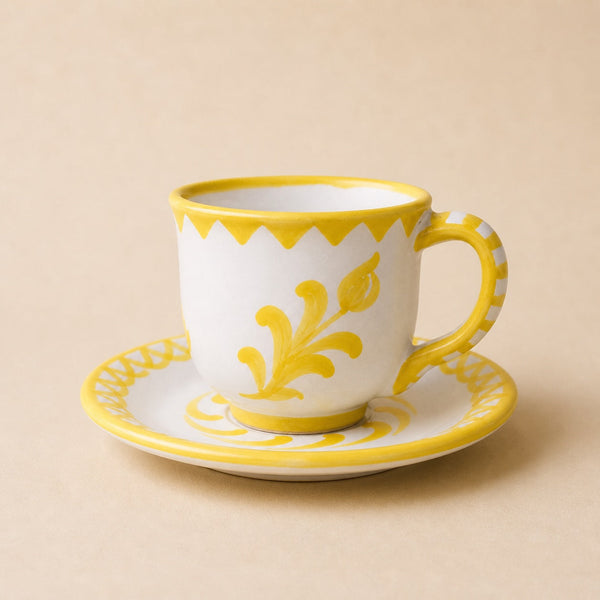 White mug with yellow floral design on a beige background