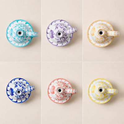 Six ceramic teapots with decorative patterns on a beige background