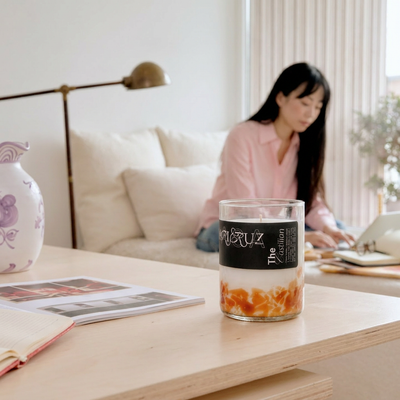 candle sent on table with person working on te background - lifestyle