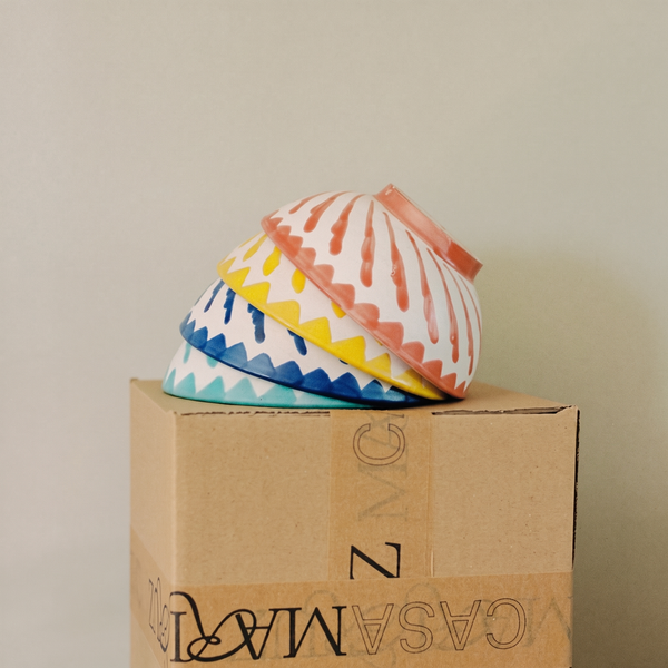 set of turquoise, blue, yellow and coral cereal bowls on top of a box - lifestyle