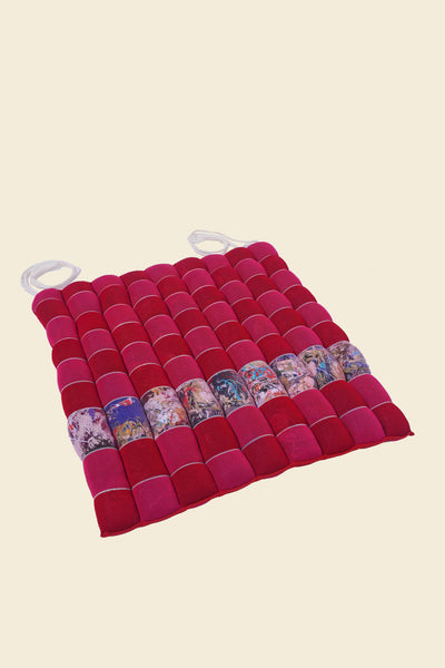front view of red/pink knit checkered seat cushion with upcycled materials with beige background 