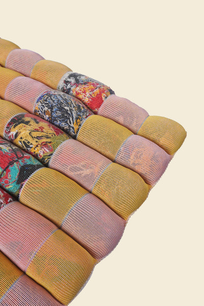 corner of yellow/pink knit checkered seat cushion with upcycled materials