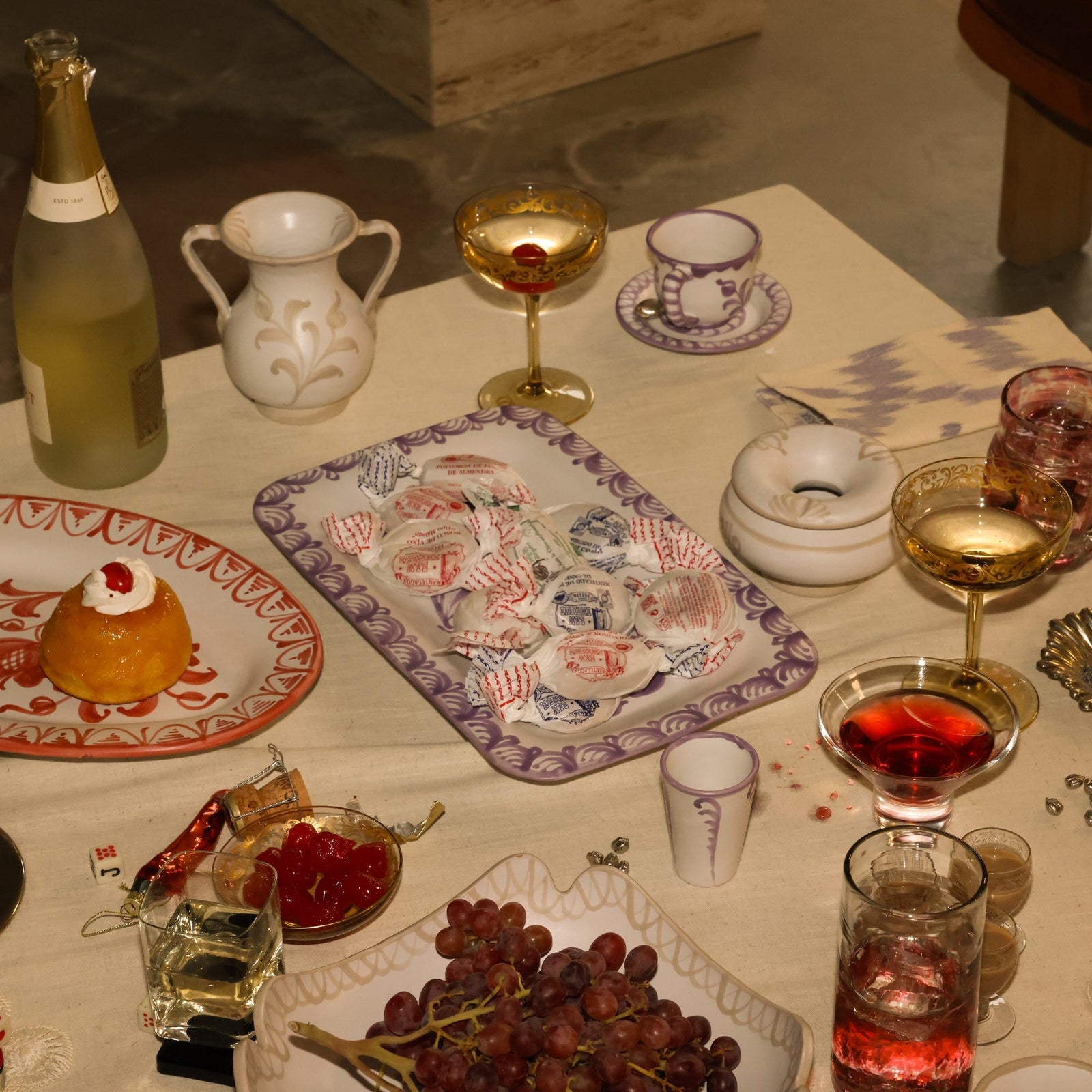 Dessert table with various items including a bottle, glasses, and food. - lifestyle