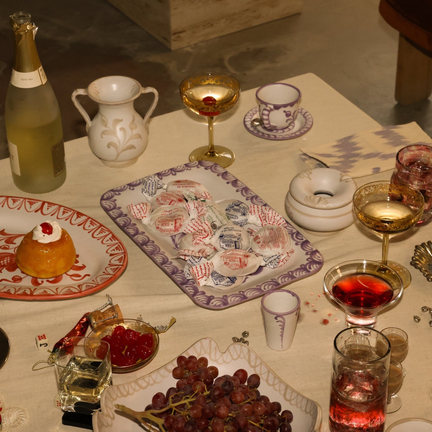 Dessert table with various items including a bottle, glasses, and food. - lifestyle