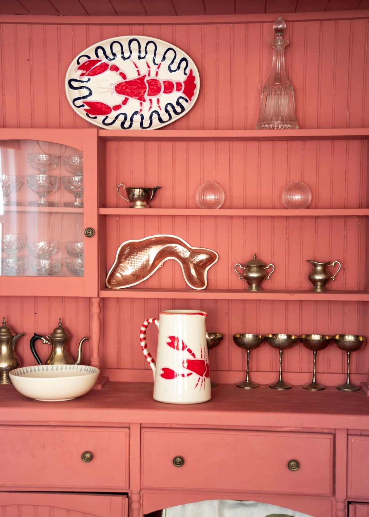 Lobster ceramic jug and lobster ceramic plate on pink cabinet