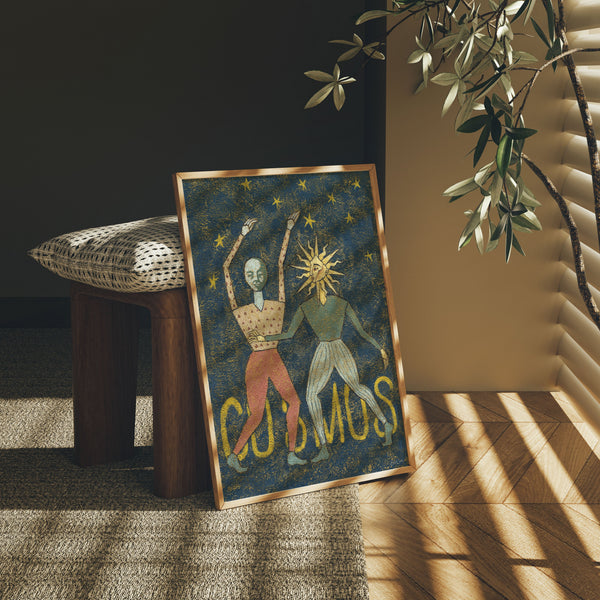 Framed artwork titled 'Cosmos' on a wooden stool with a plant in the background