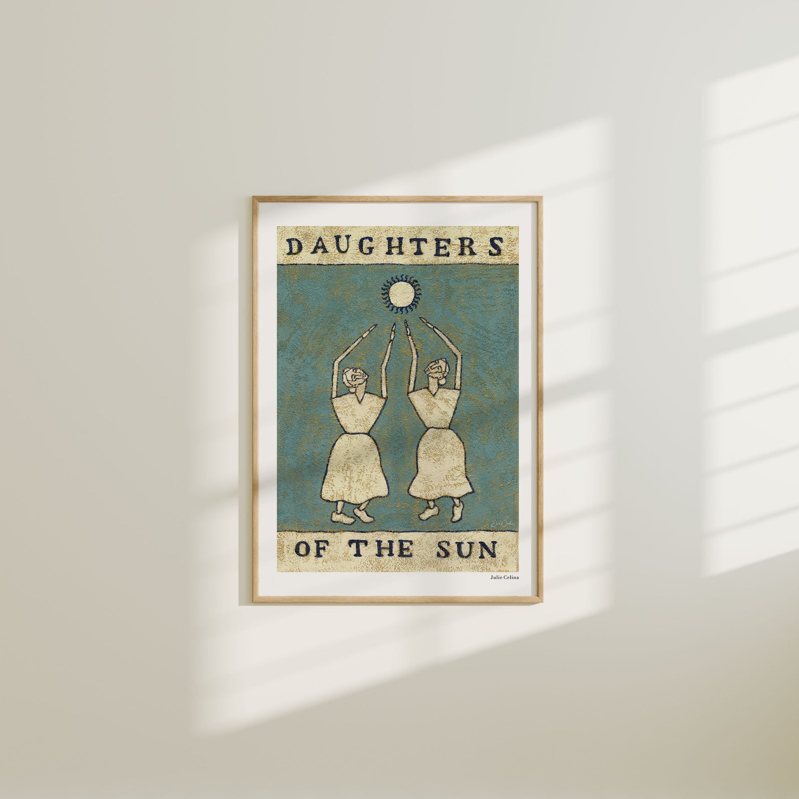 Framed artwork titled 'Daughters of the Sun' on a wall.