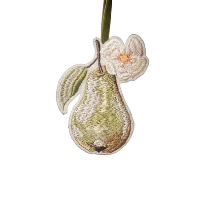 Embroidered green pear decoration with delicate white blossom and leaf, hanging from an olive green velvet ribbon.