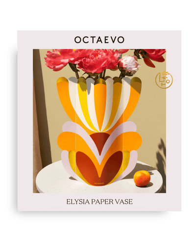The OCTAEVO Elysia Paper Vase holds pink flowers; water resistant, beside an orange.