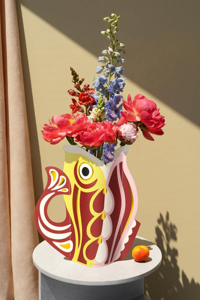 Decorative red OCTAEVO fish-shaped vase with colorful flowers. 