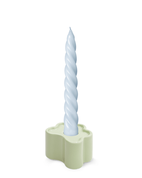 A light blue twisted candle in OCTAEVO's Flora Candle Holder in Mint, a hand-glazed ceramic flower shape, on white background.