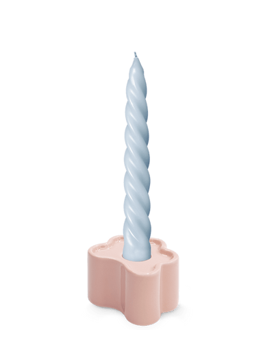 A light blue twisted candle in the hand-glazed OCTAEVO Flora Candle Holder in Pink.