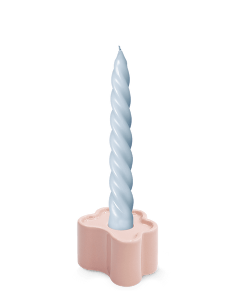 A light blue twisted candle in the hand-glazed OCTAEVO Flora Candle Holder in Pink.