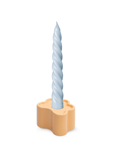 A light blue twisted candle sits in an OCTAEVO Flora Candle Holder in Orange, hand-glazed.